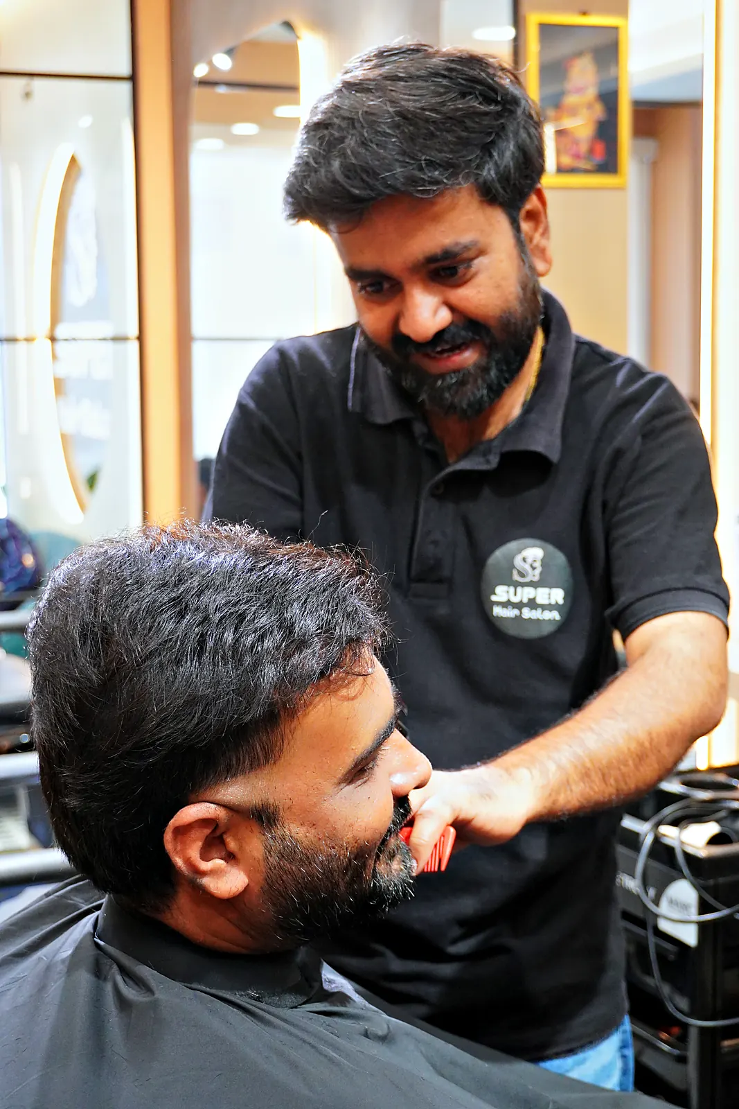 Barber laughing with a client mid-haircut