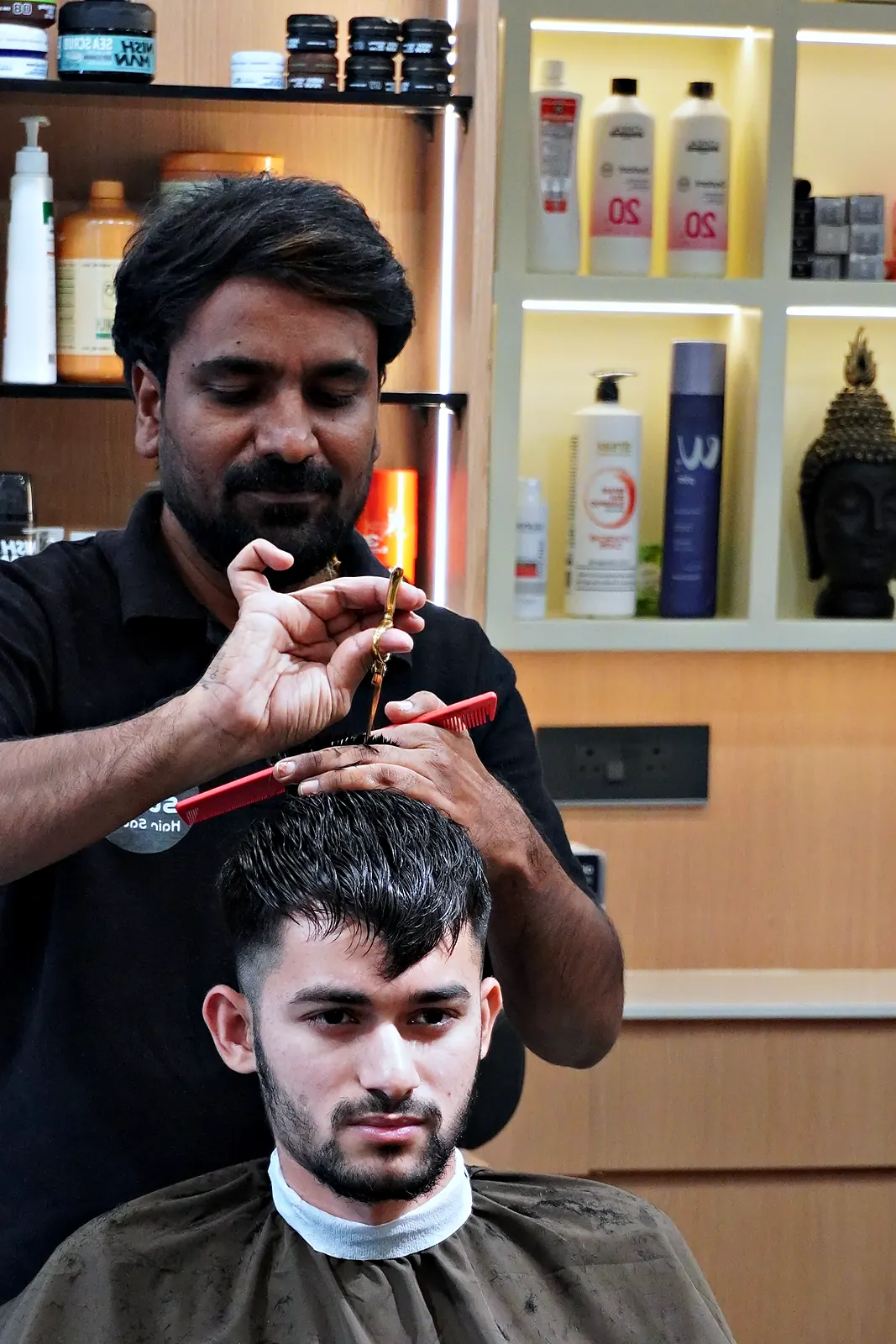 Stylist finishing a cut with scissors and comb