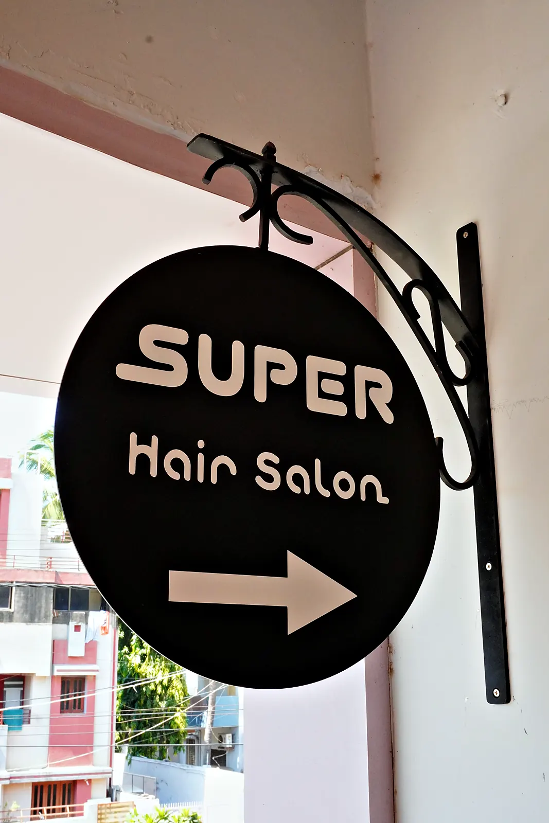 The SUPER Hair Salon hanging sign with an arrow